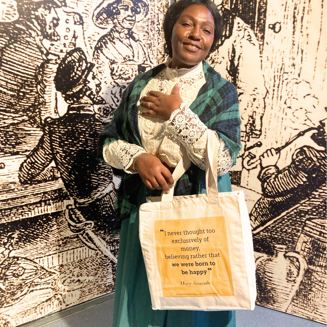 an actor dressed as Mary Seacole holds the tote bag