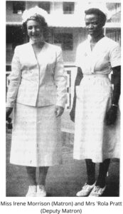 black and white photograph of two women standing next to each other, both wearing a nurses uniform. Miss Morrison, a middle aged white woman, stands on the left. Kofoworola Pratt, a younger black woman stands on the right.