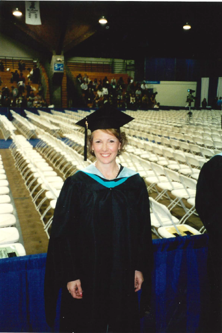 Screenshot 2026-05-21 115345 Image of Susan In Graduation Cap and Gown Facing Camera at ceremony in front of chairs