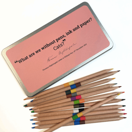 A closed metal tin featuring a Nightingale Quote on a pink background, below is a pile of wooden coloured pencils
